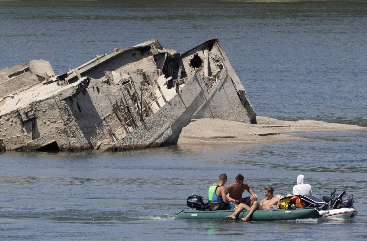 People in a boat pass by a sunken German warship from World War II exposed due to low Danube River levels in Prahovo, Serbia, People in a boat pass by a sunken German warship from World War II exposed due to low Danube River levels in Prahovo, Serbia,